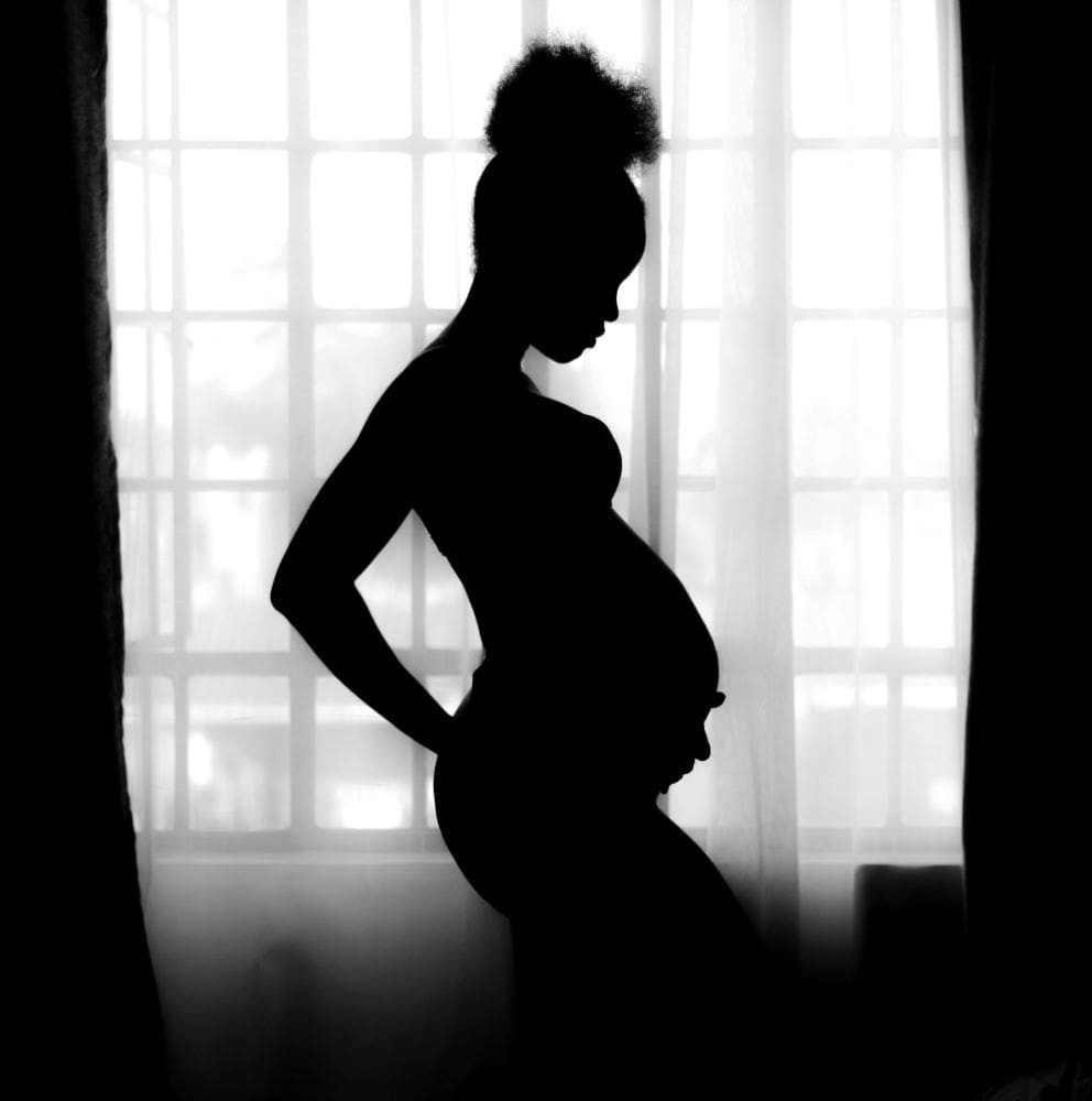 kobieta na tle okna w ciąży